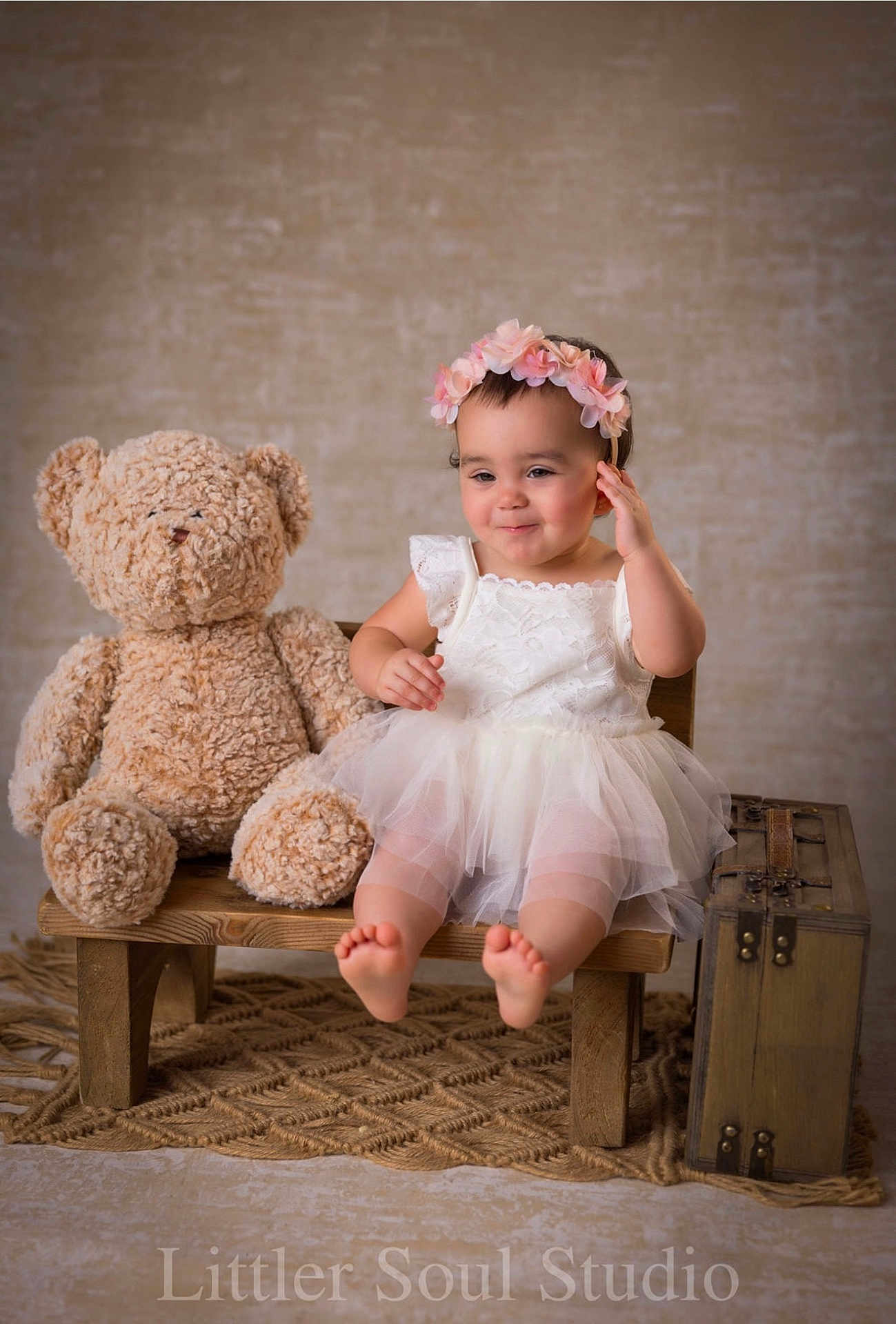 Ashley joined the competition — help win amazing prizes! baby, teddy_bear, bench, dress, flower_crown, smile, barefoot, wooden_bench, toy, child, portrait, indoor, studio, vintage_suitcase, carpet, cute, happy, childhood, soft_toys, playful