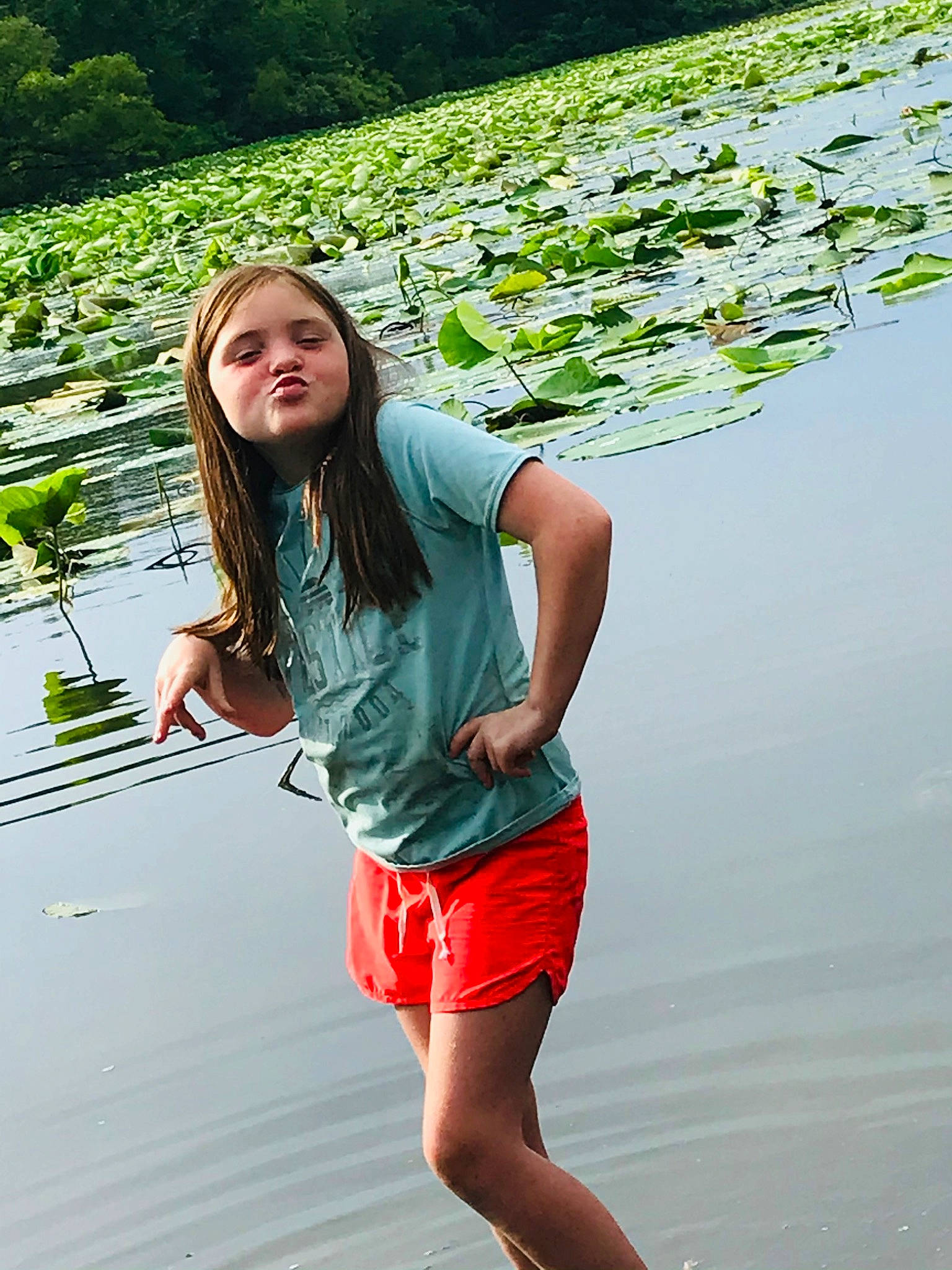 Remington is registered to the contest to win money with this photo: black_hair, flash_photography, fun, grass, green, happy, human_leg, knee, lake, leisure, long_hair, people_in_nature, person, plant, recreation, shorts, t_shirt, thigh, waist, water