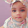 Sky joined the competition — help win amazing prizes! baby, bib, blue, blue_eyes, bow, child, close_up, clothing, cute, drool, floral_pattern, headband, indoor, infant, person, pink, portrait, purple_background, soft_lighting, yellow
