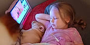 Izzy is registered to the contest to win money with this photo: child, dog, blanket, bed, tablet, screen, sleeping, indoor, pajamas, relaxing, cozy, pink, light, face, hair, couch, resting, technology, pet, sleep