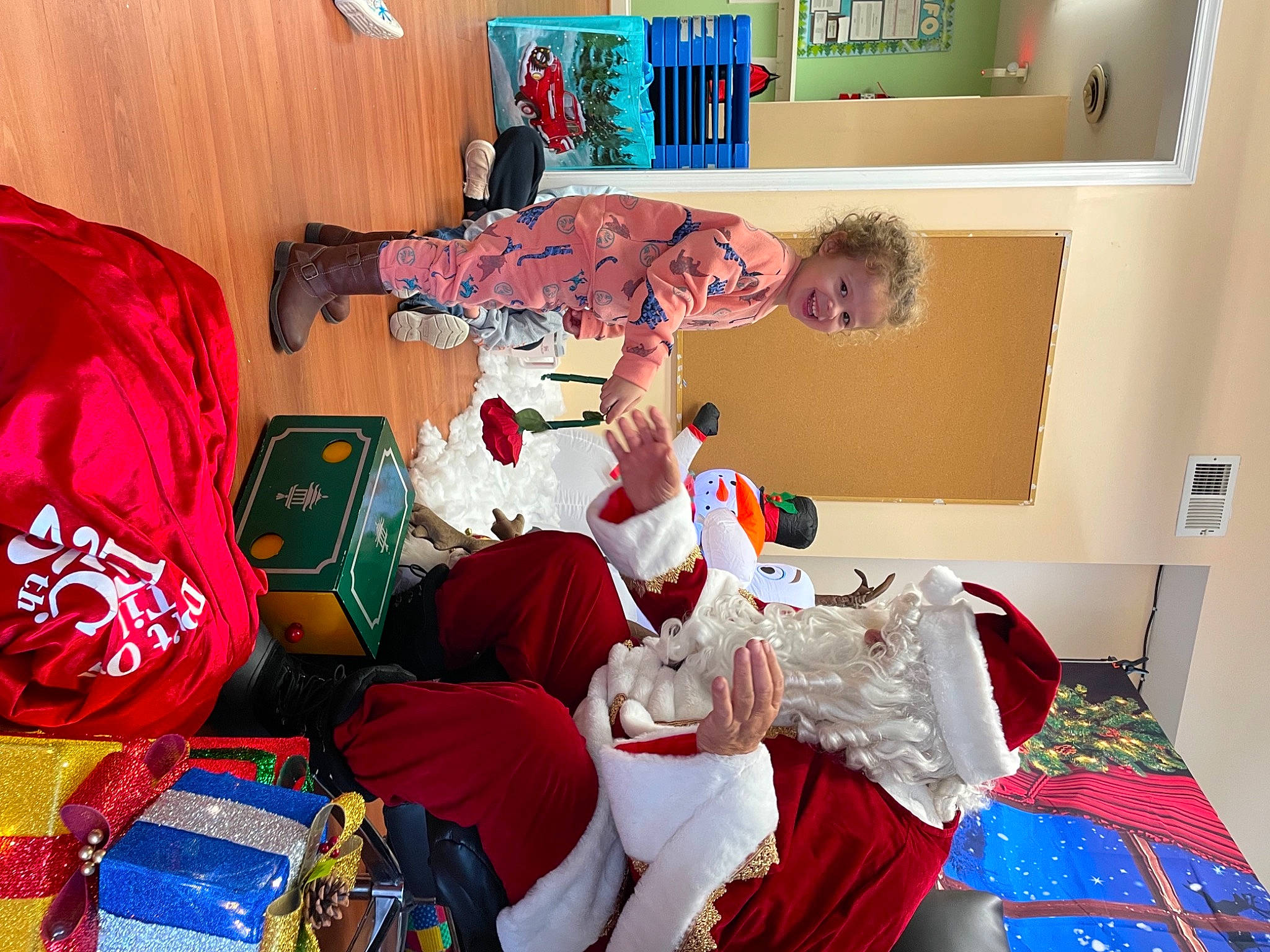 Kenzleigh is registered to the contest to win money with this photo: bookcase, carmine, christmas, christmas_eve, event, fictional_character, fun, holiday, joy, lap, linens, person, room, santa_claus, shelf, shelving, sleeve, stuffed_toy, tradition