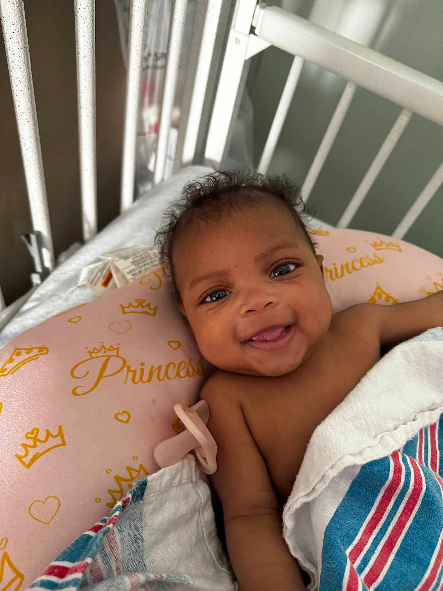 Nalyla joined the competition — help win amazing prizes! baby, smiling, infant, crib, pillow, pacifier, blanket, hospital, cute, portrait, child, face, happy, lying_down, indoors, young_child, skin, expression, head, eyes