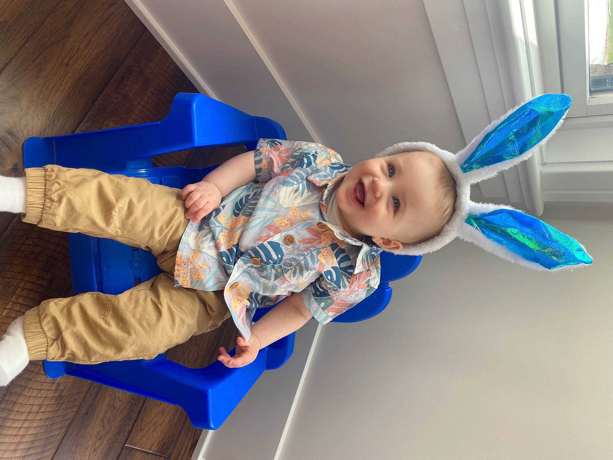 Brody is registered to the contest to win money with this photo: baby, baby_toddler_clothing, blue, ceiling, child, comfort, electric_blue, flooring, fun, happy, human_leg, joy, knee, leisure, mechanical_fan, person, sitting, smile, sock, t_shirt