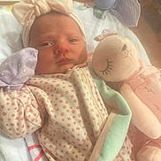 Addison is registered to the contest to win money with this photo: baby, infant, polka_dot, onesie, headband, bow, stuffed_animal, plush_toy, blanket, sleepy, cuddle, soft_toy, newborn, lying_down, indoor, cozy, child, cute, pastel_colors, face