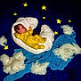 Mako is registered to the contest to win money with this photo: baby, infant, yellow_onesie, sleeping, crescent_moon, white_cushion, stars, cotton_clouds, blue_background, night_sky_theme, soft_texture, peaceful, dreamy, indoors, portrait, child, resting, fabric, cute, creative_setup