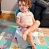Emilia And Olivia is registered to the contest to win money with this photo: child, toddler, curly_hair, serious_expression, side_eye, sitting, potty_chair, play_mat, indoor, living_room, leather_recliner, barefoot, pink_shirt, legs, portrait, home, floor, colorful, animals, family_photo
