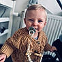 Enzo a rejoint le concours — aidez-le/la à gagner de superbes lots ! baby_accessory, blue_eyes, buttoned_sweater, child, cozy, cute, face, home, indoor, knitted, pacifier, person, portrait, smiling, stroller, sweater, toddler, warm_colors, wooden_beads, young_child