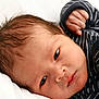 baby, babywear, closeup, clothing, cute, eyes, face, fist, hand, head, infant, lying_down, newborn, portrait, skin, sleeping, soft_light, striped, white_background, young_child