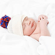 Mkilye is registered to the contest to win money with this photo: baby, newborn, sleeping, hat, pom_pom, blanket, white, soft, cozy, infant, peaceful, cute, child, resting, knit, warm, portrait, closeup, skin, hand