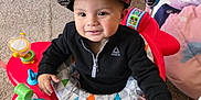 Mkilye is registered to the contest to win money with this photo: baby_walker, black_jacket, cap, carpet, child, colorful, cute, face, furniture, hand, happy, hat, headwear, indoor, living_room, person, playtime, smile, toddler, toy