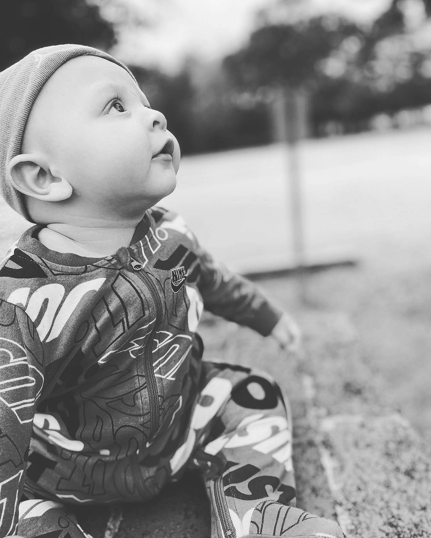 Malachi is registered to the contest to win money with this photo: baby, baby_toddler_clothing, black_and_white, child, eye, face, flash_photography, fun, grass, happy, head, monochrome, monochrome_photography, people_in_nature, person, sitting, skin, smile, style, toddler