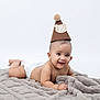 baby, infant, diaper, blanket, hat, party_hat, smiling, cute, lying_down, soft_texture, celebration, portrait, child, adorable, young, happy, skin, headwear, pom_pom, studio