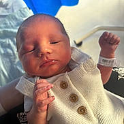 Kaison is registered to the contest to win money with this photo: newborn, baby, infant, sleeping, white_clothing, knitted, buttons, hand, hospital_wristband, indoor, person, closeup, peaceful, portrait, skin, face, resting, curled_hand, blue_curtain, soft_light
