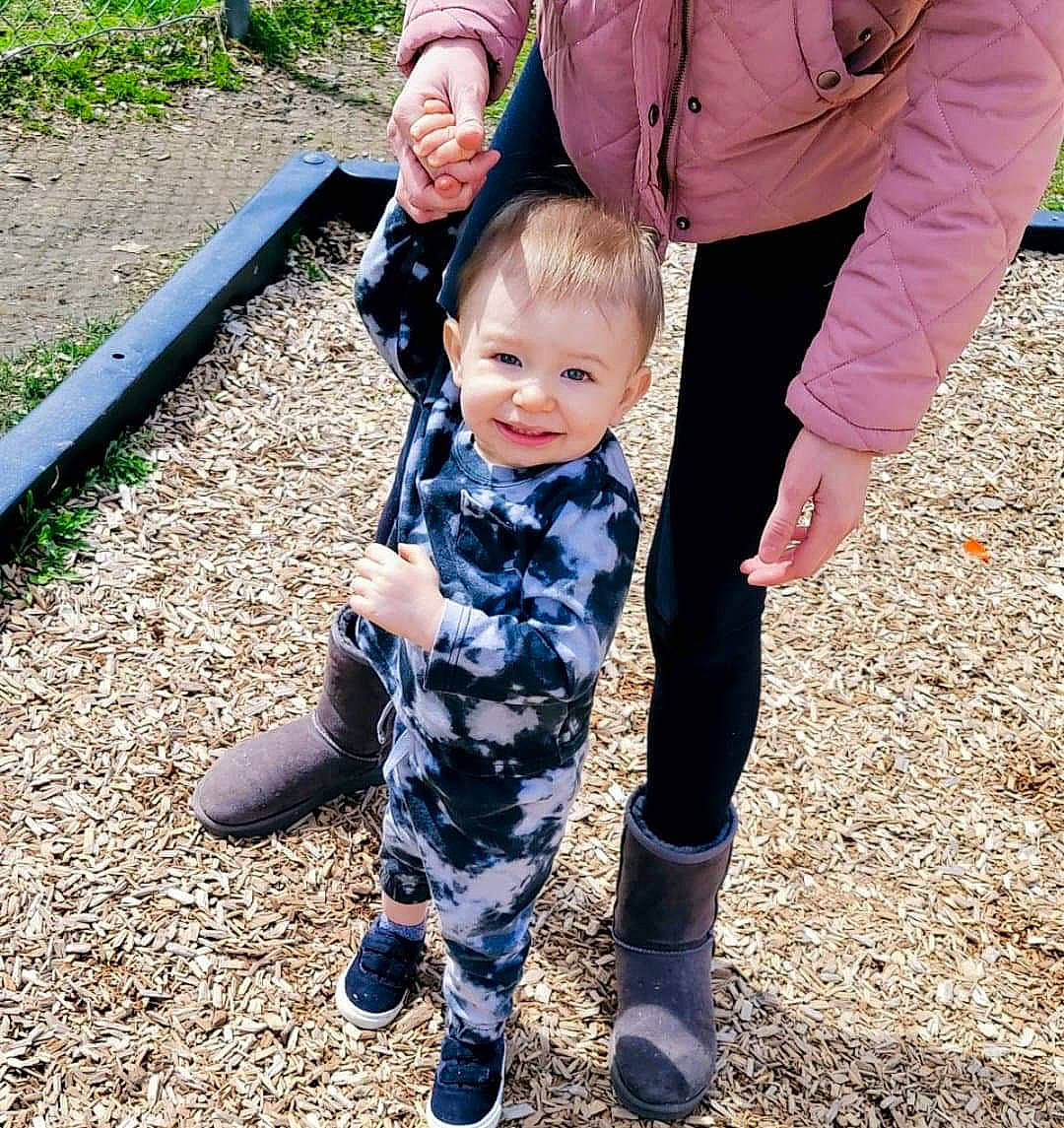 Damien joined the competition — help win amazing prizes! baby, baby_toddler_clothing, boot, child, event, formal_wear, fun, gesture, grass, happy, holding_hands, joy, people_in_nature, person, play, shoe, sitting, sleeve, smile, sneakers