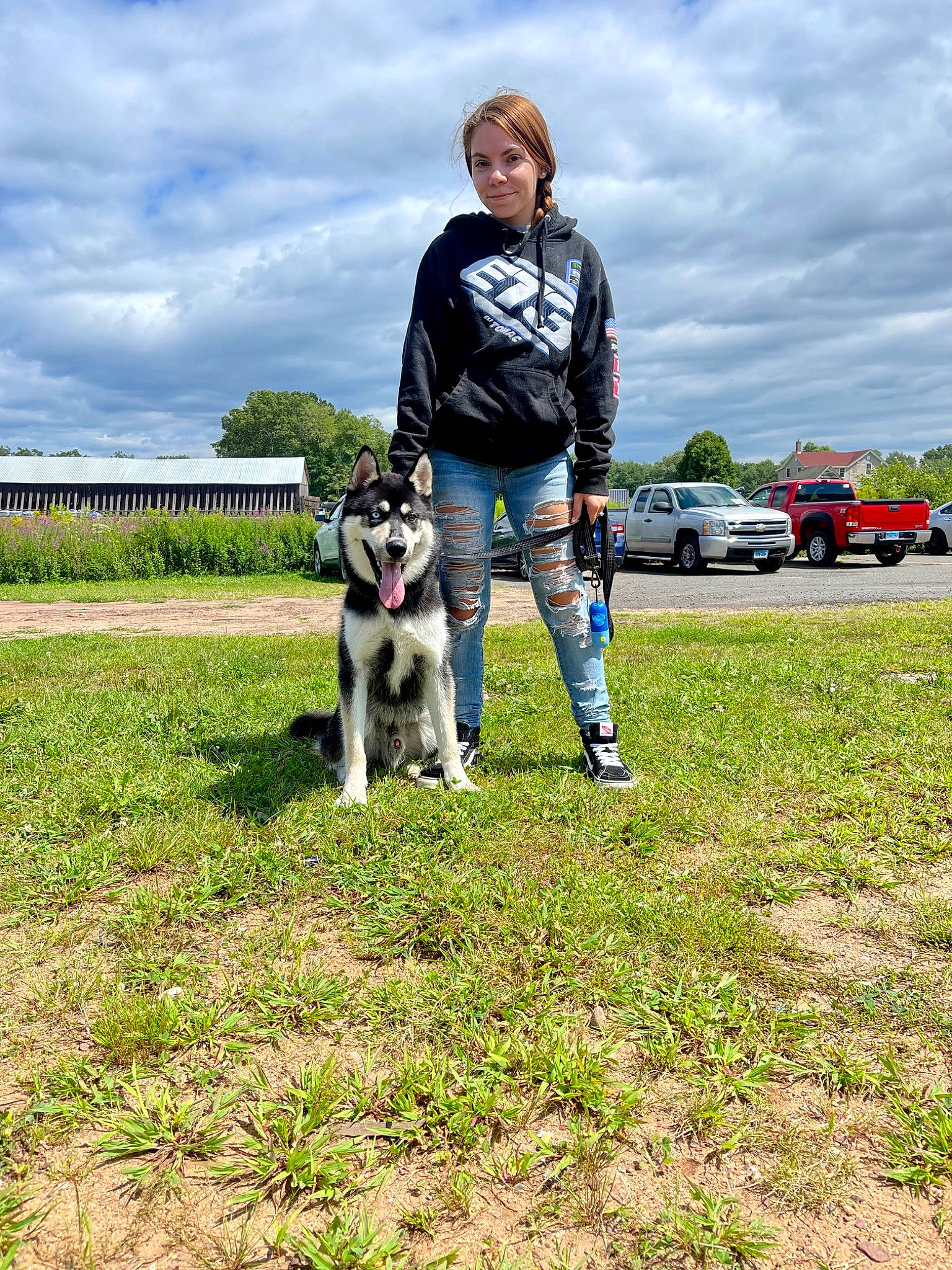 Juno is registered to the contest to win money with this photo: carnivore, cloud, companion_dog, dog, dog_breed, grass, grassland, jeans, leash, leisure, pasture, recreation, sky, sporting_group, tire, toy_dog, tree, truck, walking, wheel