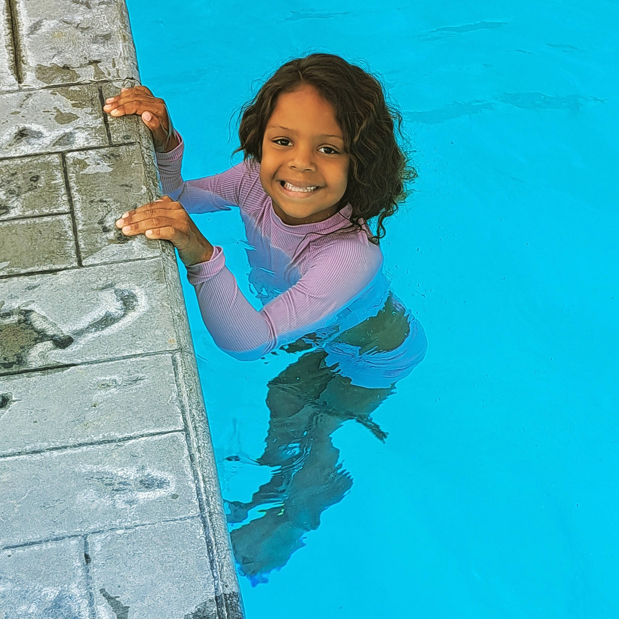 Maycee is registered to the contest to win money with this photo: adventure, arm, blue, child, elbow, electric_blue, fun, gesture, happy, joy, leisure, people_in_nature, person, recreation, rock, sitting, smile, thigh, toddler, travel