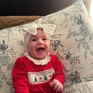 Beatrice joined the competition — help win amazing prizes! baby, bow, celebration, child, christmas_theme, cozy, cute, face, festive, floral_pattern, happy, headband, holiday_outfit, indoor, infant, pillow, portrait, red_clothing, sitting, smiling