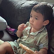 Yonathan joined the competition — help win amazing prizes! toddler, child, pajamas, snack, rice_cake, couch, leather, indoor, window, plants, home, relaxed, sitting, cute, face, person, food, leisure, comfort, young_child