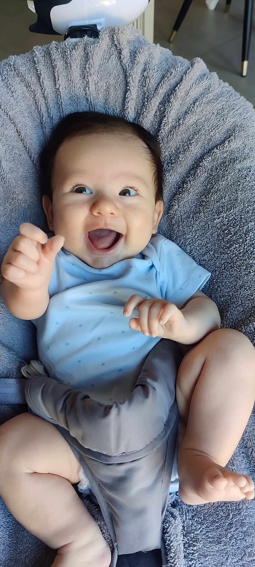 éric participe au concours pour gagner de l'argent avec cette photo : baby, infant, smiling, happy, blue_clothing, plush_seat, soft_texture, cute, child, young, indoors, seated, playful, chubby_legs, hand_gesture, bright_eyes, joyful, comfort, casual, portrait