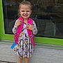 Nova is registered to the contest to win money with this photo: backpack, child, concrete, cute, daylight, dress, ghost_pattern, girl, green_frame, outdoor, person, pink_socks, playful, pumpkin_pattern, reflection, sidewalk, smiling, white_shoes, window, young