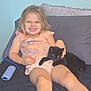 Nova joined the competition — help win amazing prizes! child, girl, smile, kitten, black_cat, couch, pillow, remote_control, socks, shorts, shirt, indoor, happy, pet, animal, relaxing, cute, young_child, furniture, home