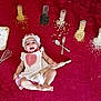 baby, blanket, chef_costume, cooking, cute, food, fork, grains, headwear, indoors, infant, kitchen_tools, laying_down, playful, red_blanket, rolling_pin, smiling, spoon, whisk, white_clothing