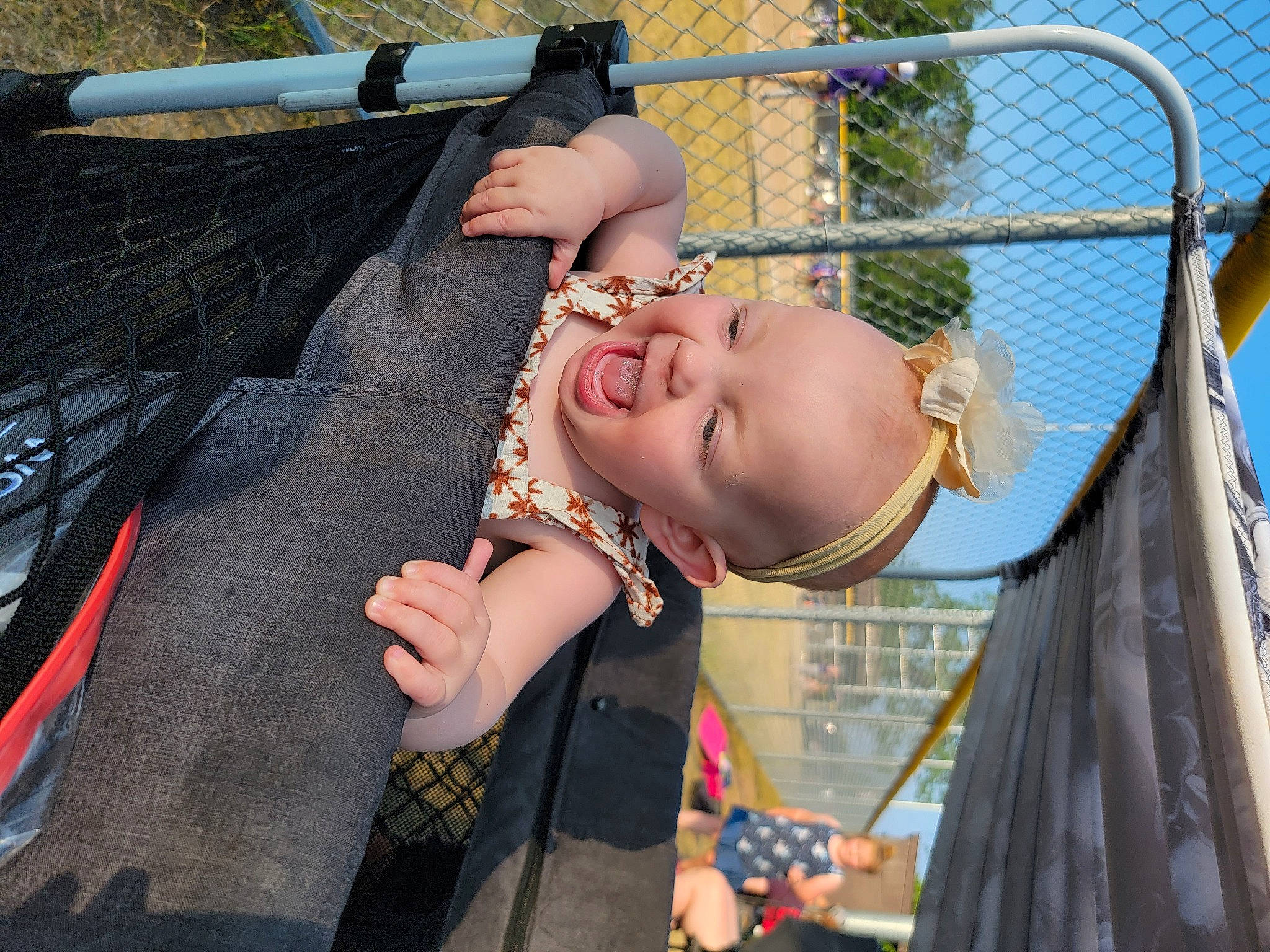 Solei is registered to the contest to win money with this photo: baby, baby_products, blurred, child, eyewear, fence, fun, grass, happy, jewellery, leisure, outdoor_play_equipment, person, recreation, sky, smile, swing, toddler, tree