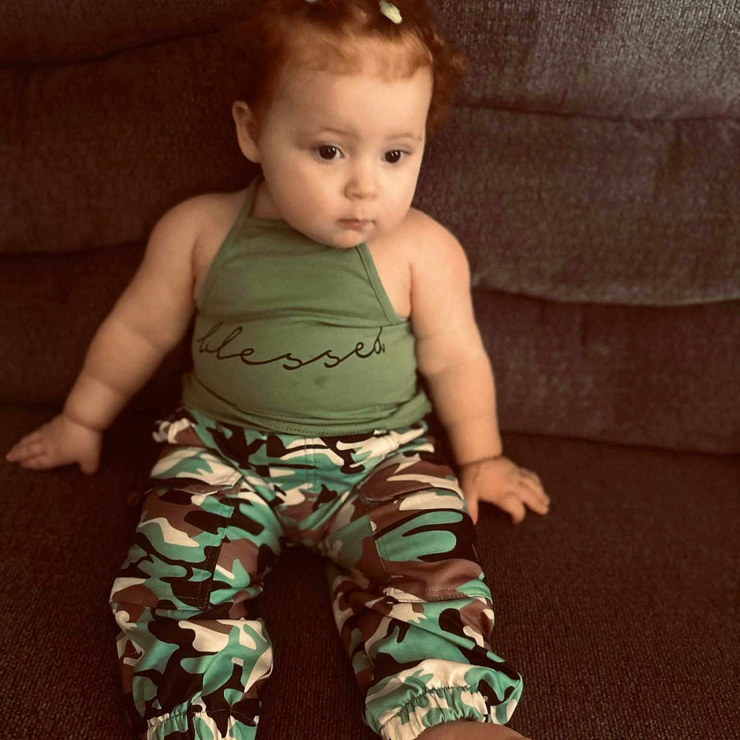 Ava is registered to the contest to win money with this photo: baby, bodypart, clothing, couch, crawling, cushion, dress, face, finger, furniture, hand, head, homedecor, pajamas, pants, person, photography, portrait, shorts, sitting