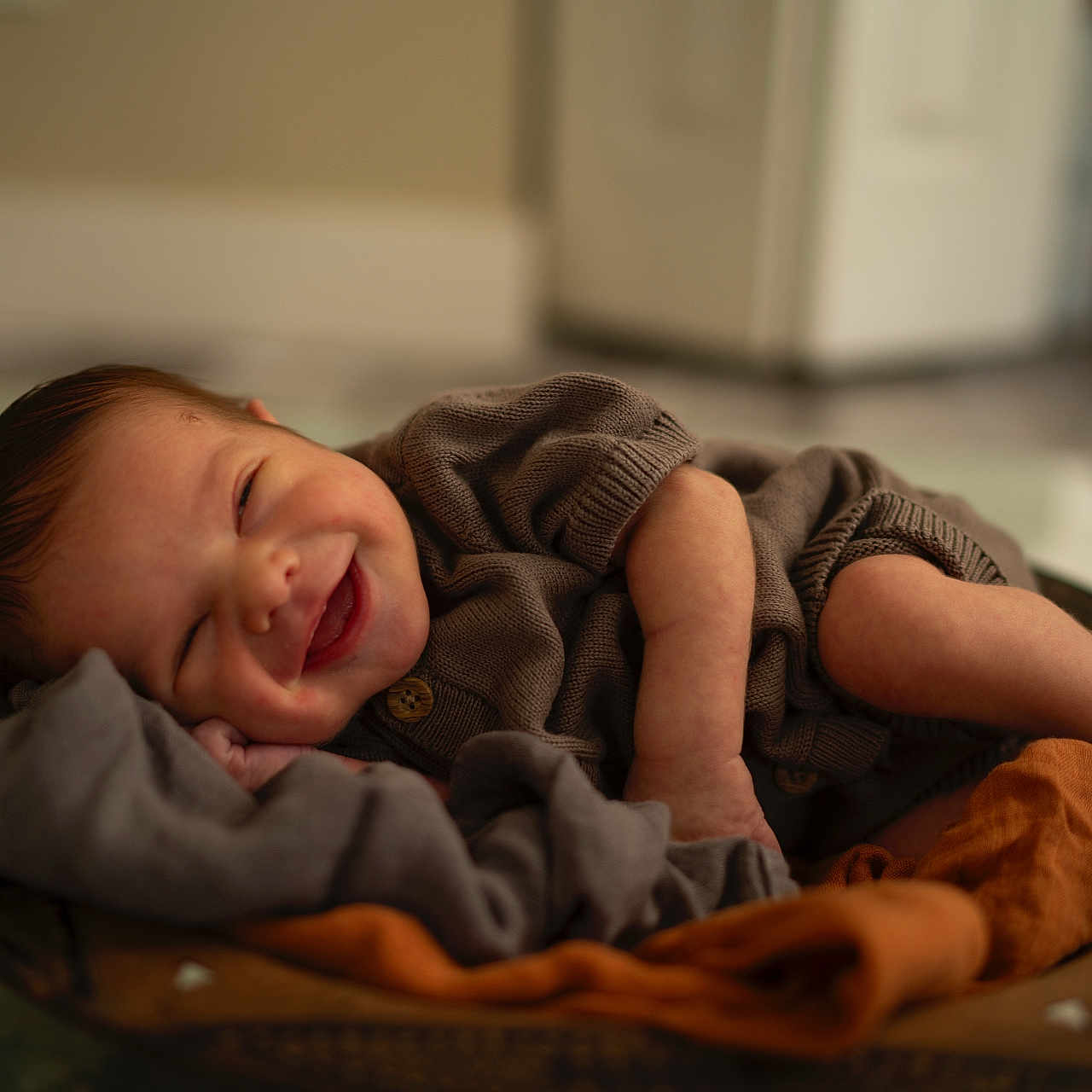 Idris is registered to the contest to win money with this photo: baby, blanket, bowl, clothing, cozy, cute, face, feet, hands, happy, indoors, infant, newborn, portrait, resting, skin, sleeping, smiling, soft, warm