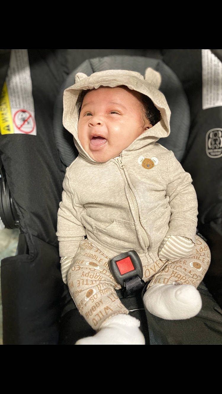 Josiah is registered to the contest to win money with this photo: baby, baby_carriage, baby_products, baby_toddler_clothing, car_seat, carmine, cheek, child, comfort, fun, happy, headwear, hood, outerwear, person, product, sitting, skin, sleeve, smile