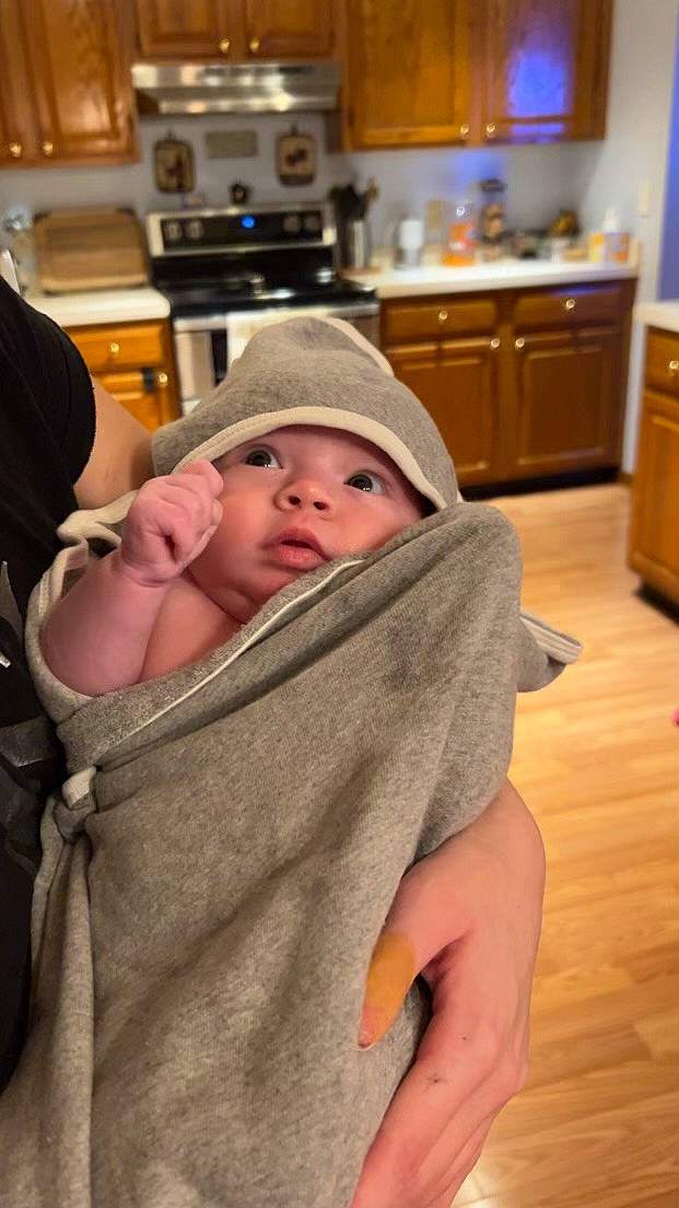 Kinsley is registered to the contest to win money with this photo: baby, cabinetry, child, comfort, countertop, cupboard, drawer, flooring, gas_stove, hardwood, headwear, home_appliance, kitchen, kitchen_appliance, kitchen_stove, microwave_oven, person, room, sitting, skin