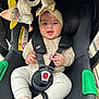 baby, baby_toys, car_seat, child, close-up, clothing, comfort, cute, happy, headband, indoor, infant, infant_clothing, person, safety, seat, seat_belt, small_child, smiling, toy
