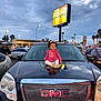 bow, car, child, cloudy_sky, dusk, gmc, headlights, laundromat, outdoor, parking_lot, people, pink_dress, reflection, sign, sitting, smiling, toddler, trees, urban, vehicle