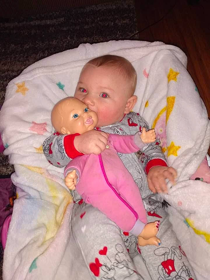 Reign is registered to the contest to win money with this photo: baby, baby_products, baby_toddler_clothing, carmine, cheek, child, comfort, eye, head, human_body, iris, lip, nose, person, pink, product, sitting, skin, sleeve, thumb