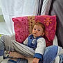 toddler, child, chair, blanket, towel, sock, clothing, indoor, person, face, curious, sitting, plastic_chair, patterned_sock, pillow, casual_wear, young_child, relaxed, home, comfort