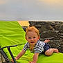 toddler, child, beach, sunset, lounge_chair, green_chair, stone_wall, sand, sea, outdoor, happy, smiling, striped_shirt, shorts, sunlight, nature, playful, portrait, baby, vacation