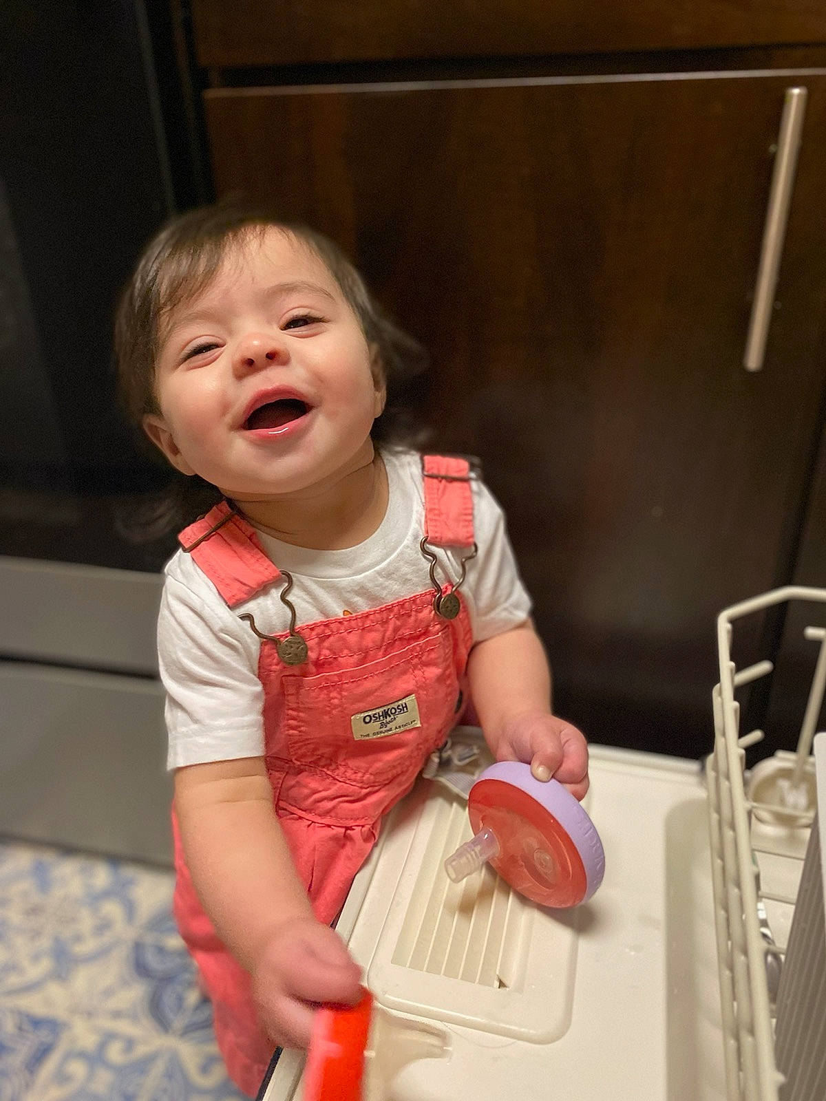 Amalia is registered to the contest to win money with this photo: arm, baby, baby_toddler_clothing, cheek, child, dress, face, facial_expression, fun, happy, head, household_supply, mouth, person, room, sitting, skin, sleeve, smile, thumb