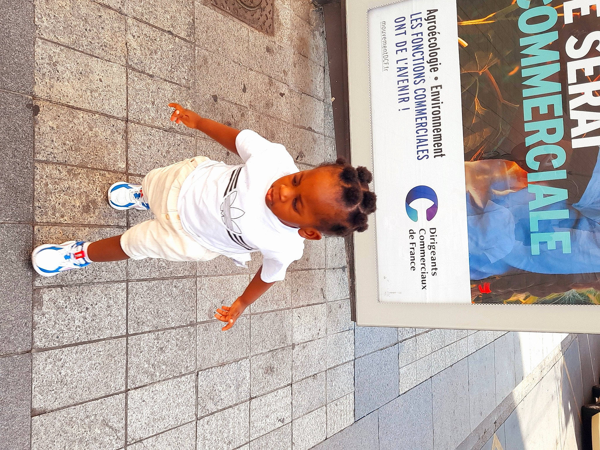 Kelyan a rejoint le concours — aidez-le/la à gagner de superbes lots ! advertising, concrete, design, eyewear, facade, flooring, font, hat, orange, pedestrian, person, recreation, sidewalk, street, street_fashion, t_shirt, walking_shoe, world