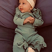 Adriana participe au concours pour gagner de l'argent avec cette photo : baby, bow, child, clothing, comfortable, cozy, cushion, cute, footwear, green_outfit, happy, headband, indoor, infant, portrait, ruffles, sitting, smiling, sock, young_child