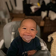 Qassim participe au concours pour gagner de l'argent avec cette photo : baby, high_chair, smile, food, waffle, indoor, child, happy, face, clothing, person, cute, infant, table, home, furniture, portrait, seat, meal, cozy