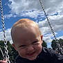 toddler, child, swing, playground, outdoor, sky, clouds, trees, grass, smile, happy, person, daytime, park, fun, baby, clothing, chain, face, nature