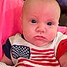 baby, infant, face, eyes, clothing, american_flag, blanket, portrait, indoor, cute, child, person, red, white, blue, sitting, expression, skin, head, young
