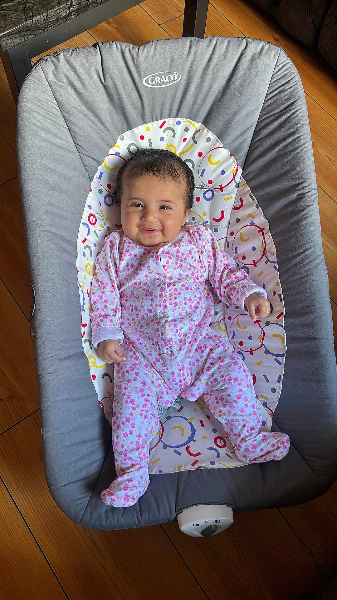 Ayat joined the competition — help win amazing prizes! baby, child, smiling, onesie, pink, floral_pattern, baby_rocker, graco, reclining, wooden_floor, indoor, cute, infant, happy, person, clothing, seat, footed_pajamas, baby_girl, portrait