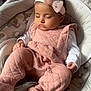 baby, sleeping, pink_outfit, headband, bow, baby_rocker, cushion, elephant_pattern, infant, cozy, cute, child, soft_lighting, indoors, peaceful, resting, adorable, portrait, young_child, clothing