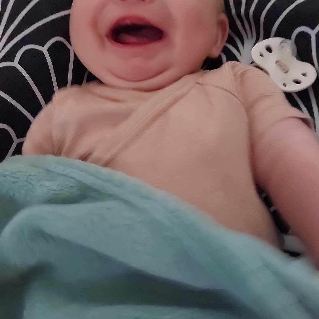 Konrad a rejoint le concours — aidez-le/la à gagner de superbes lots ! baby, blanket, child, closeup, clothing, comfort, cute, face, happy, head, indoors, infant, laughing, pacifier, patterned_background, portrait, sitting, smile, soft_texture, toddler