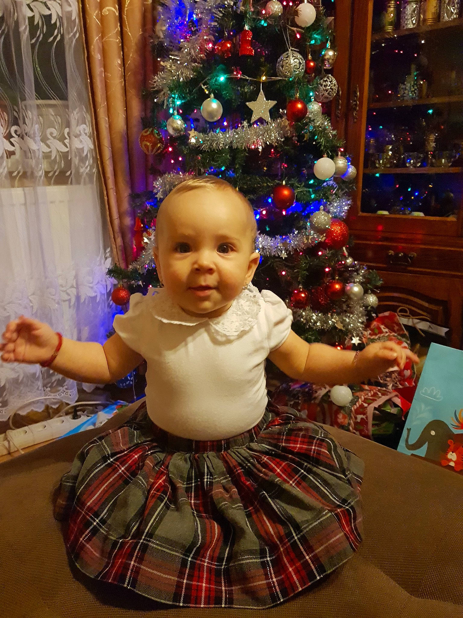 Delia is registered to the contest to win money with this photo: child, christmas, christmas_decoration, christmas_tree, event, girl, holiday, pattern, person, smile, toddler