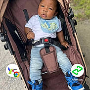 Carmelo joined the competition — help win amazing prizes! baby, stroller, child, blue_sneakers, dinosaur_bib, casual_clothing, outdoor, curious_expression, infant, seatbelt, baby_boy, young_child, pavement, greenery, casual_pose, daylight, footwear, headwear, baby_fashion, protective_seat