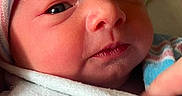 Celesté is registered to the contest to win money with this photo: baby, blanket, cap, cheek, close_up, cozy, eyes, face, hand, hospital_blanket, infant, lips, newborn, newborn_baby, nose, portrait, skin, sleepy, striped_hat, swaddle