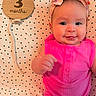 Aurora joined the competition — help win amazing prizes! baby, infant, child, smile, pink_clothing, headband, bow, polka_dot, blanket, wooden_sign, months, cute, portrait, happy, skin, face, eyes, hand, lying_down, indoors