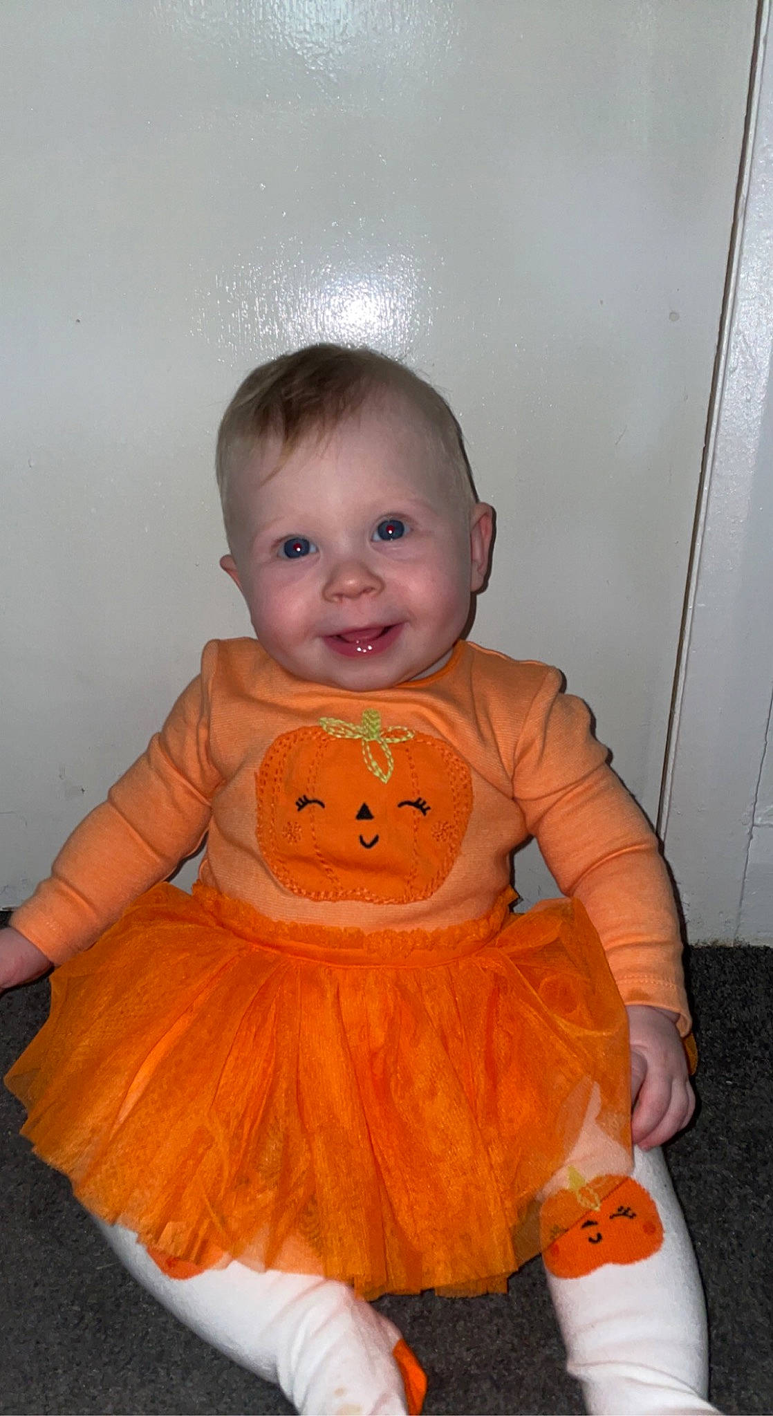 Olivia is registered to the contest to win money with this photo: baby_toddler_clothing, cheek, chin, dress, eye, facial_expression, hairstyle, iris, joy, nose, orange, outerwear, person, pink, product, pumpkin, skin, sleeve, smile, standing